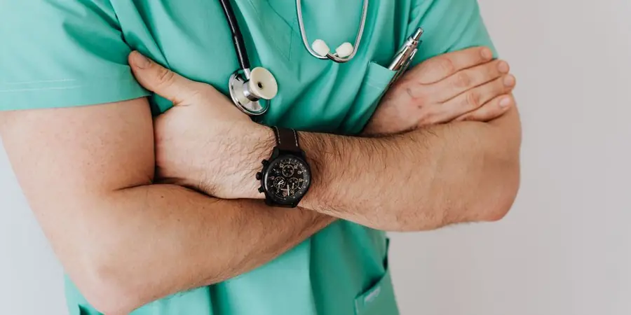Healthcare worker in scrubs with arms crossed