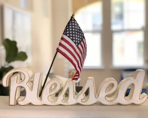 Small American flag beside a wooden “Blessed” sign
